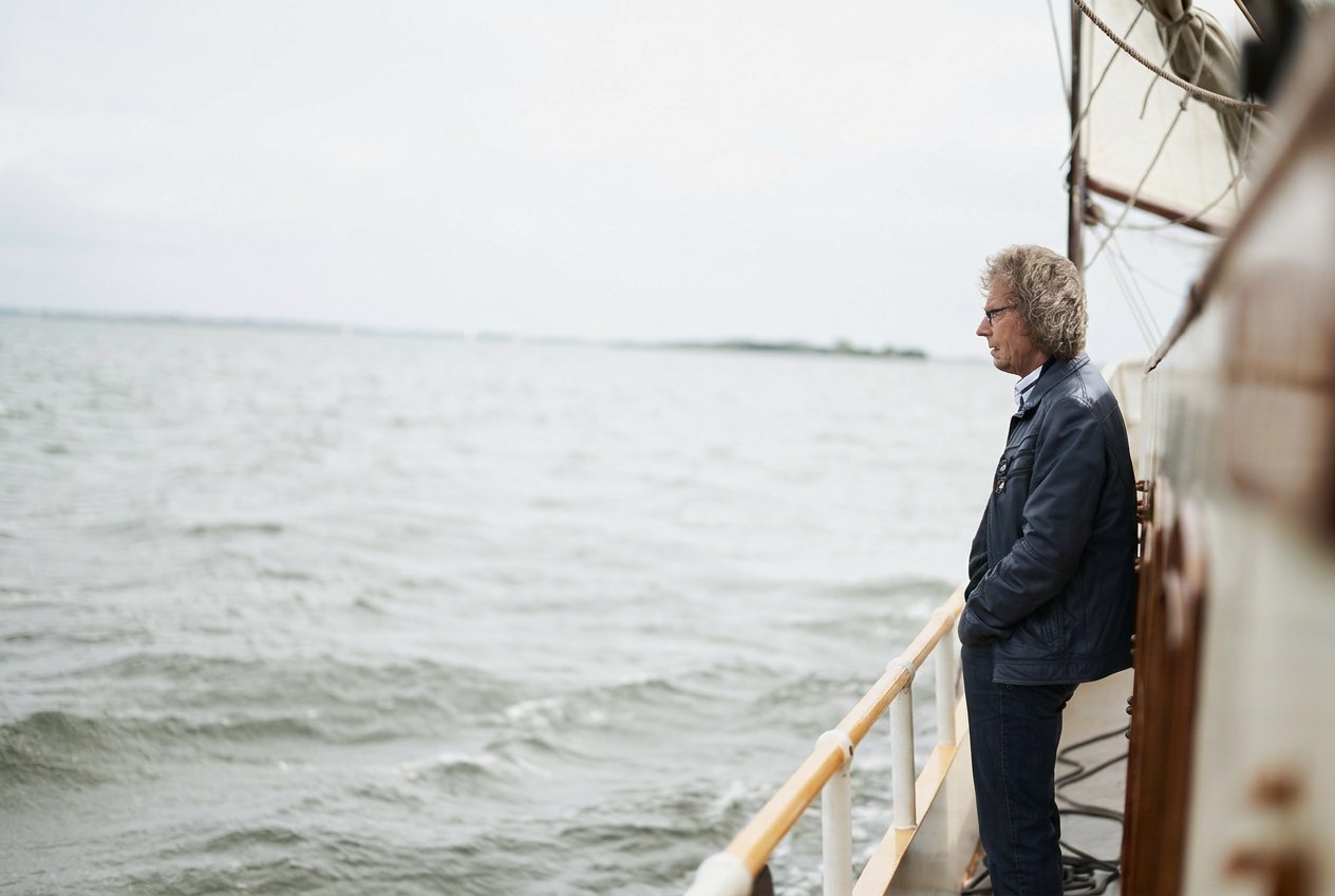 Bruiloftsgast kijkt uit over het open water van het Markermeer bij Muiden